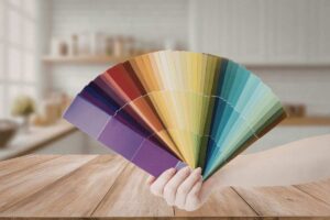 sfondo di una cucina moderna e in primo piano una mano che mantiene una palette di colori