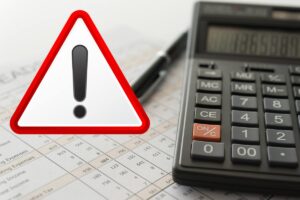 calcolatrice fogli e simbolo attenzione in rosso