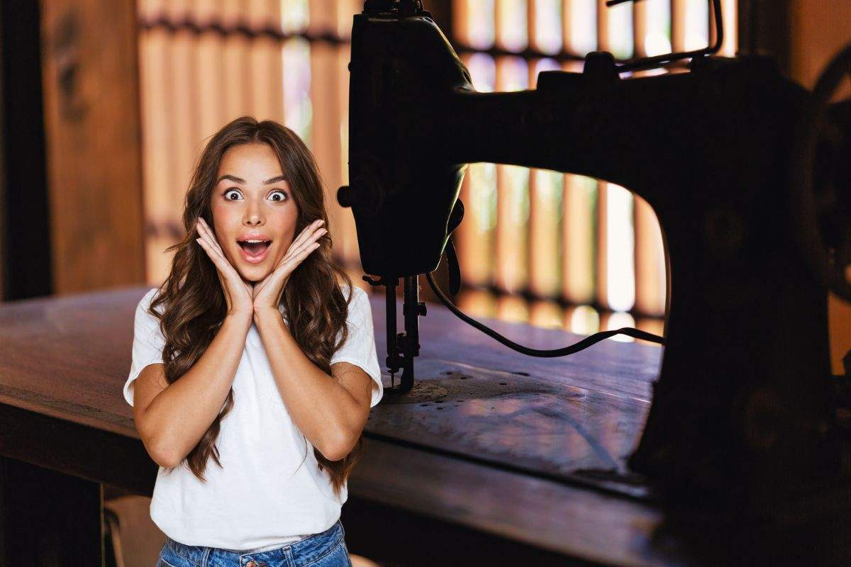 donna stupita e vecchia macchina per cucire