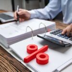 uomo con calcolatrice e segno di percentuale