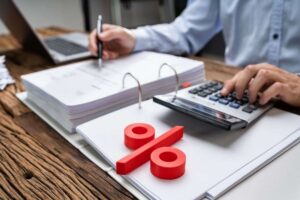 uomo con calcolatrice e segno di percentuale