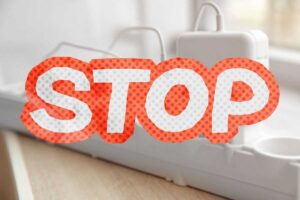 caricabatterie attaccati ad una presa multipla e scritta stop