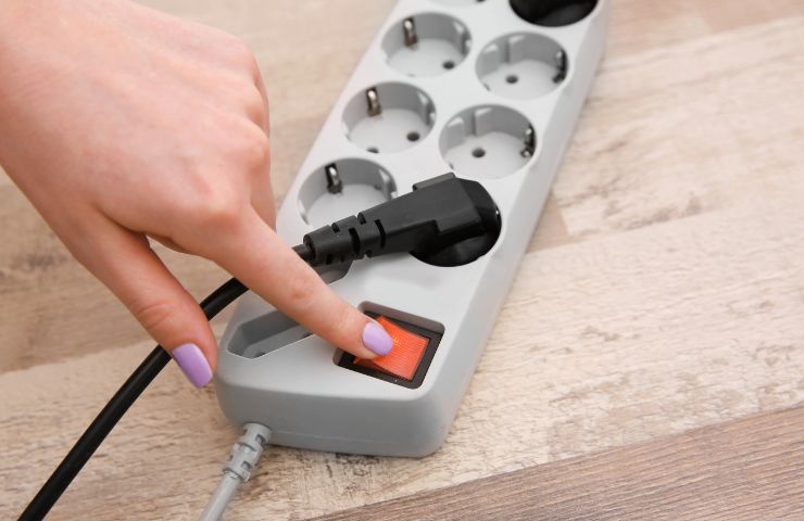 donna che spegne presa multipla