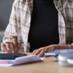 uomo con calcolatrice che fa i conti