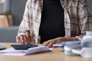 uomo con calcolatrice che fa i conti