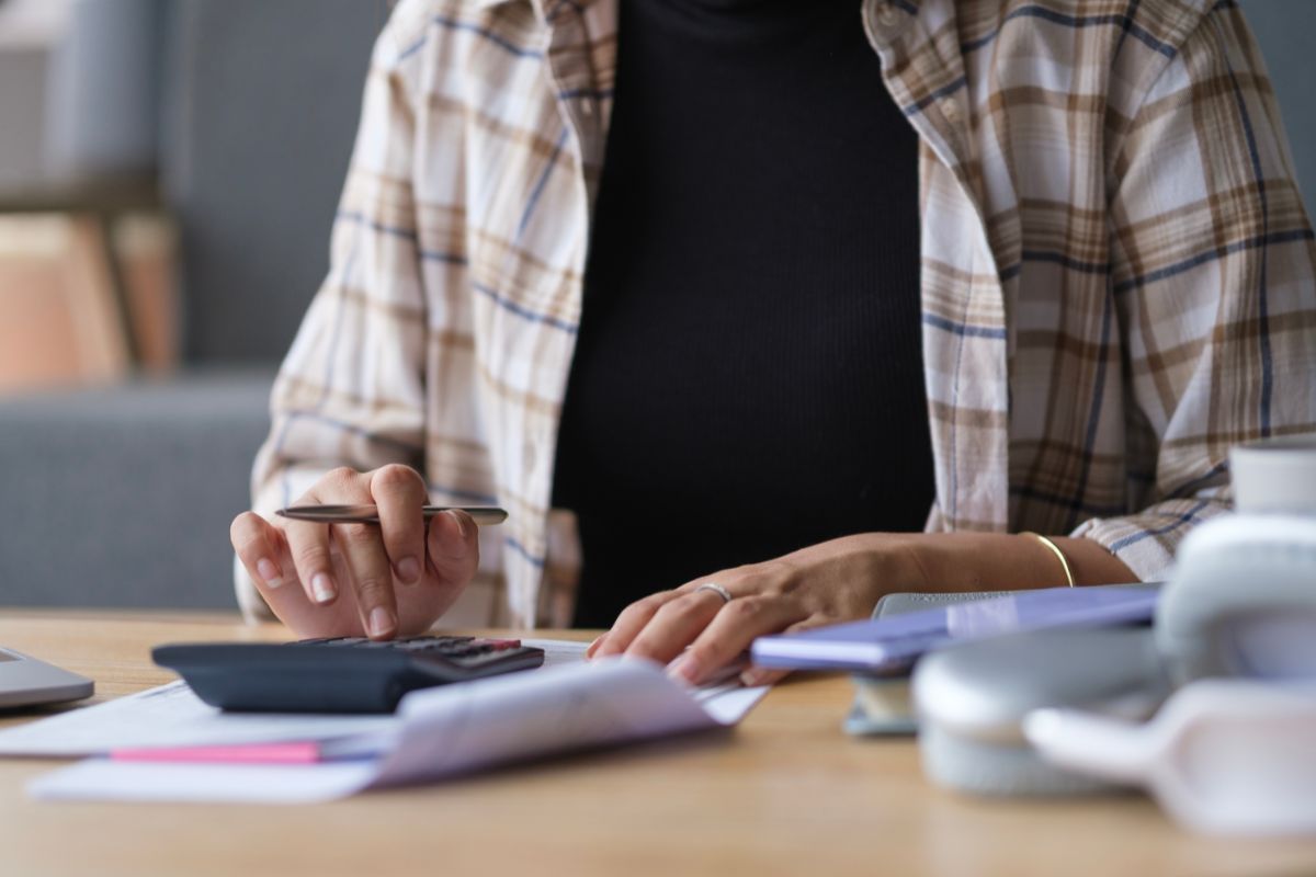 uomo con calcolatrice che fa i conti