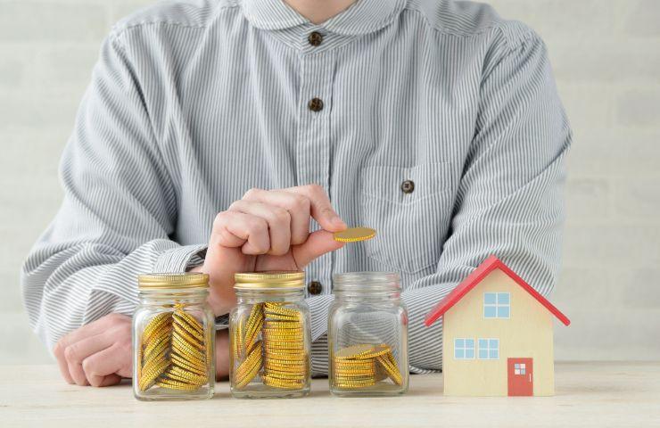 uomo mette soldi in barattoli di vetro e condominio